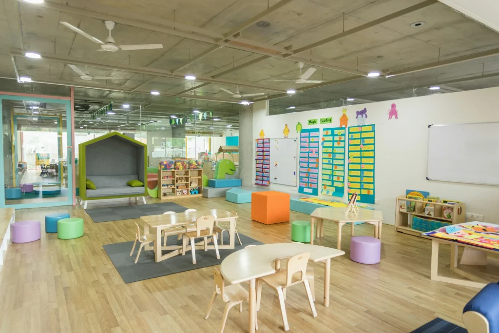 Bright, clean child care center classroom with small tables and learning materials