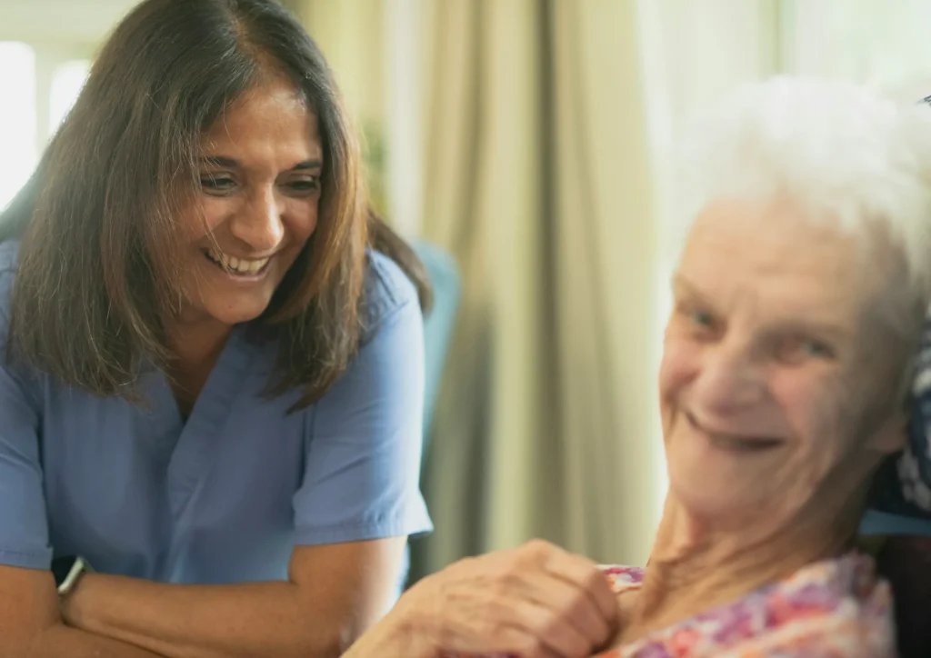 Smiling caregiver spending time with an elderly client in a senior care setting