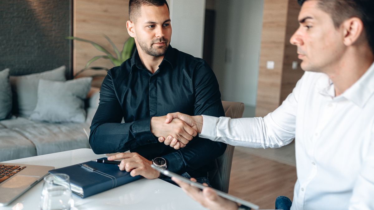 Business owner shaking hands with a funding specialist across a desk