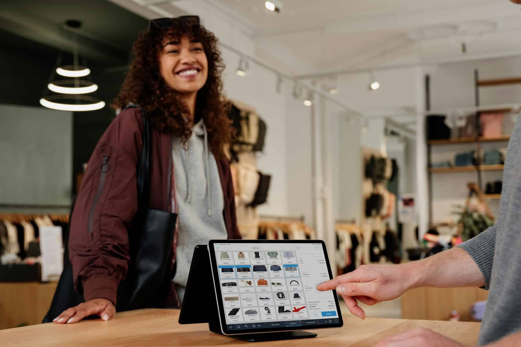Small Business Loans | Funding for Your Business 7 Smiling shop owner at the counter with a tablet