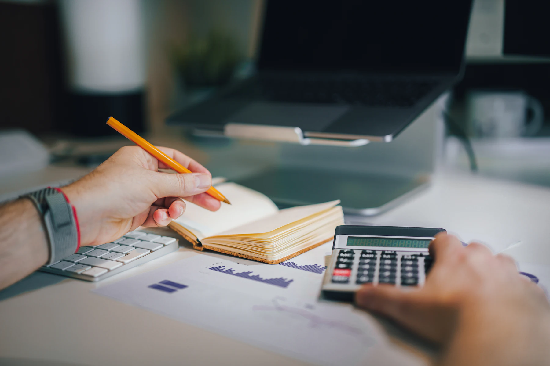 What Happens If Your Business Has 5 NSFs in the Last 3 Months? 2 Person sitting at a desk with a calculator and a notebook