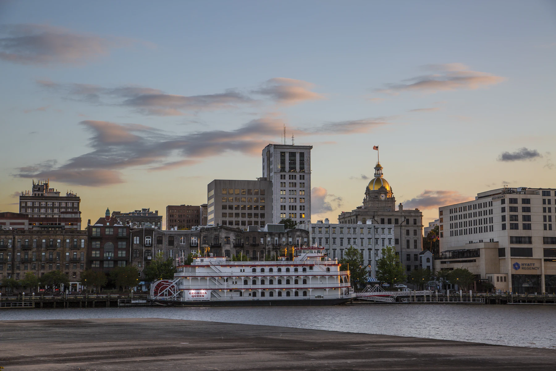 5 Reasons Georgia Business Owners Get Business Financing in 2026 2 White and brown boat on the water near Savannah buildings at sunset