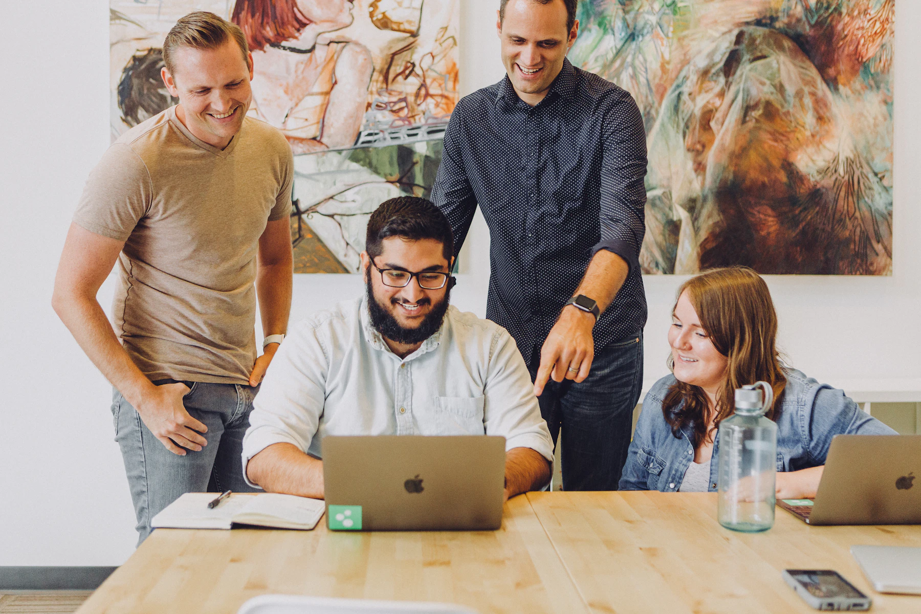 Business Loan Affiliate Program vs Referral Program vs ISO Program 2 Four coworkers smiling around a laptop at a table