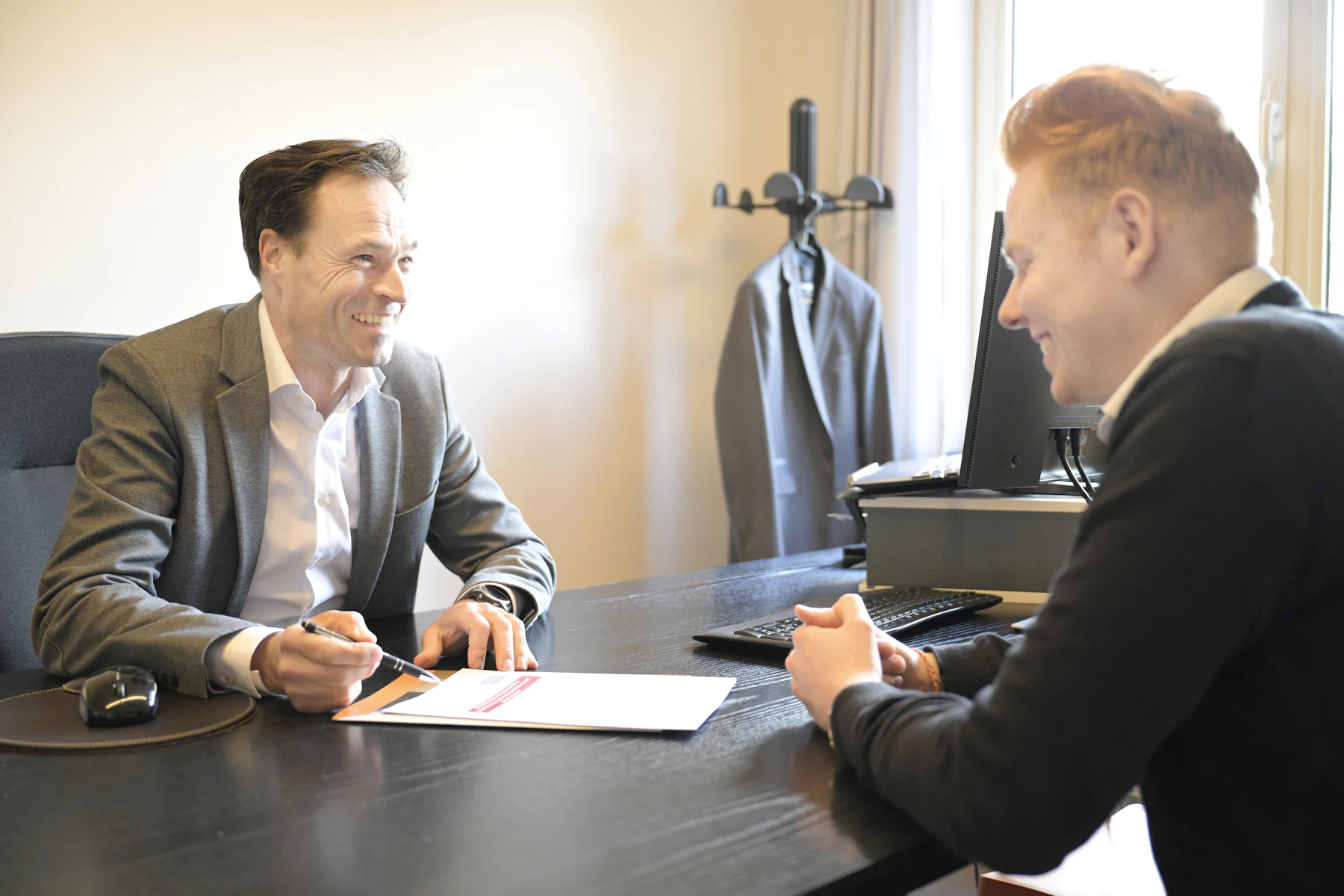 Business Loan Referral Program for Accountants and CPAs 2 Two smiling men discussing documents at an office desk