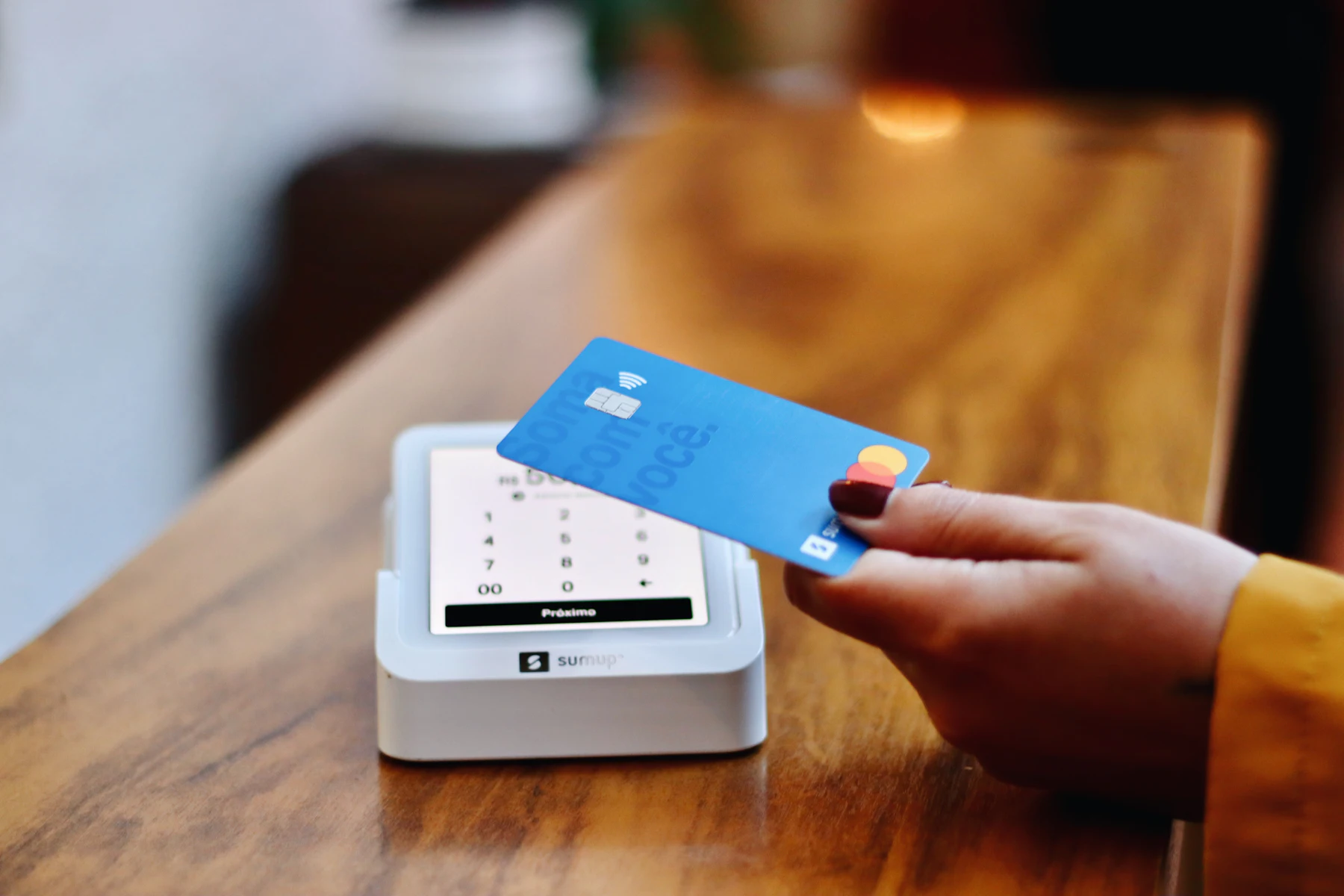 Business Loan Referral Program for Payment Processing and POS Reps 2 Person holding a credit card in front of a machine
