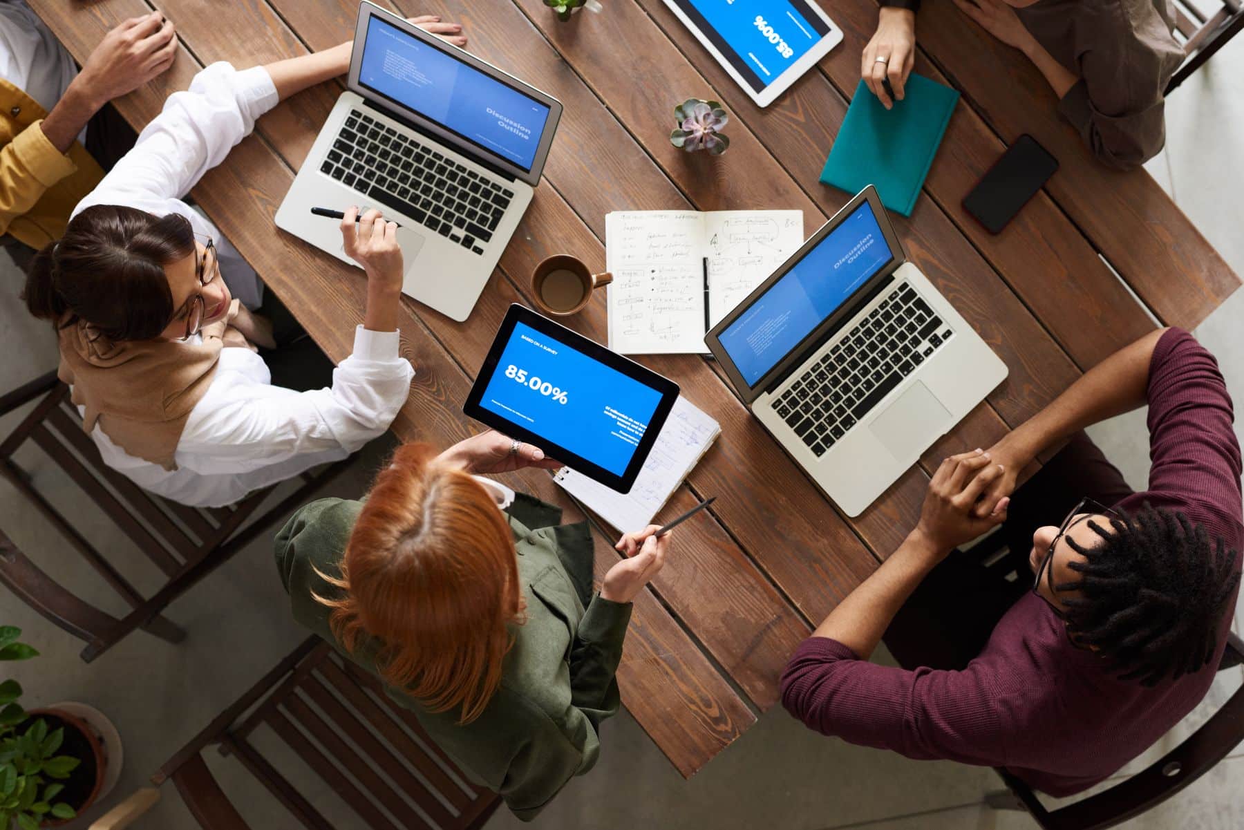 Team of entrepreneurs working on laptops around a shared table