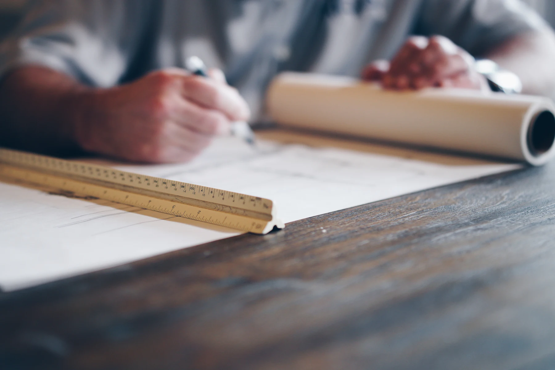 Bridge Funding for Contracts: How to Cover Costs Before the Customer Pays 2 Person drawing up plans on a blueprint
