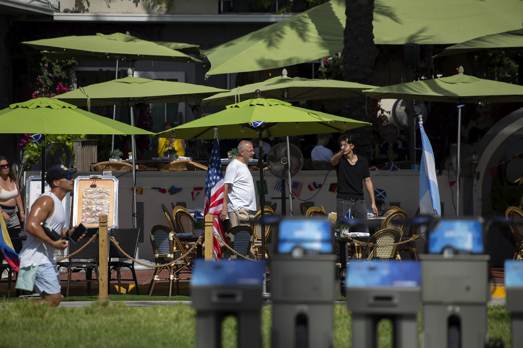 Get Your Business Ready Before the Busy Season Gets Here 2 People near an outdoor cafe with green umbrellas