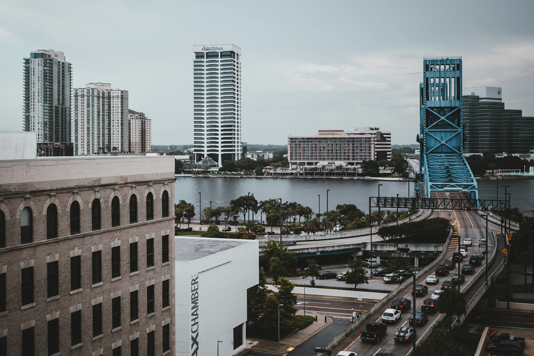 Financiamiento para Negocios en Florida: Opciones, Requisitos y Cómo Recibir Fondos Rápido (2026) 2 Edificios altos y un puente junto al río en el centro de una ciudad