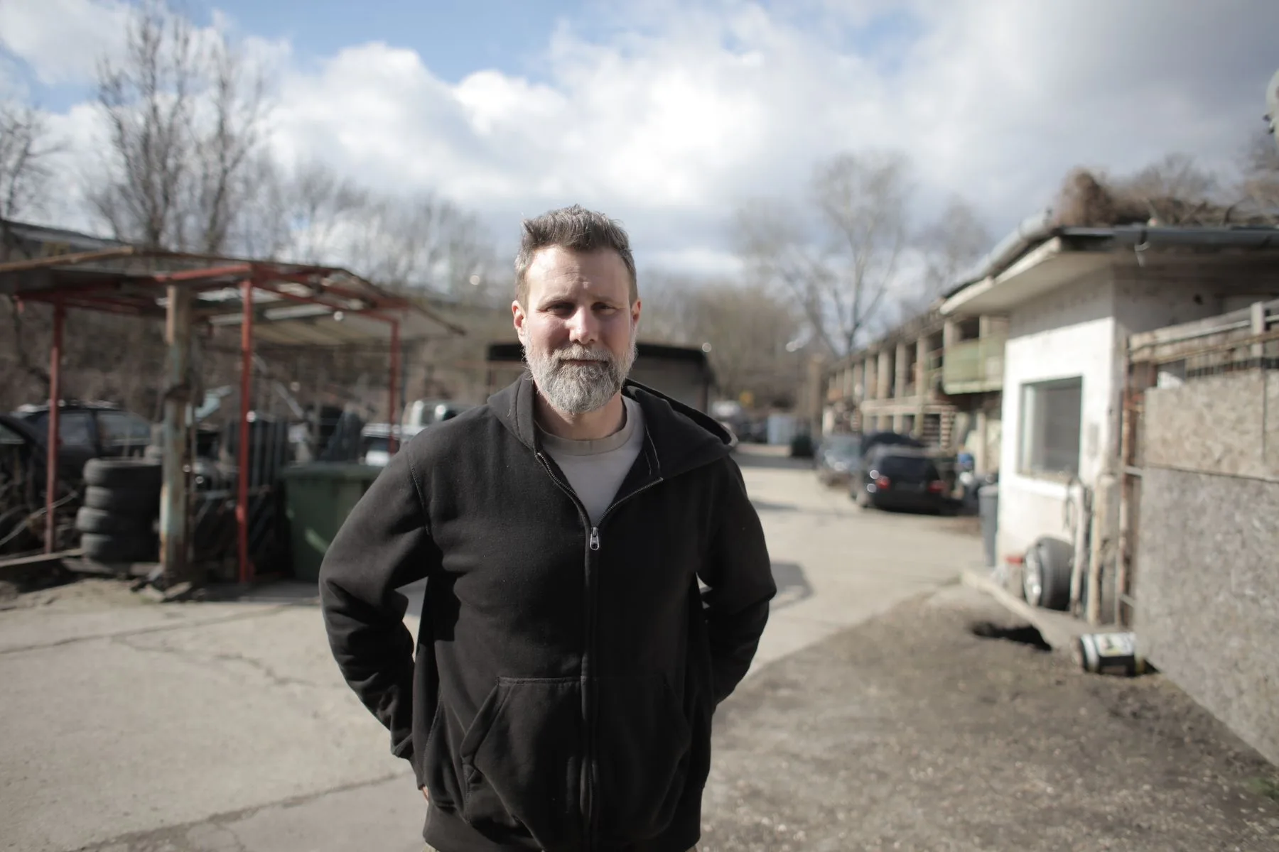 How Business Loans Work for Established Businesses: A Guide 2 Auto repair shop owner standing at the open door of his service bay