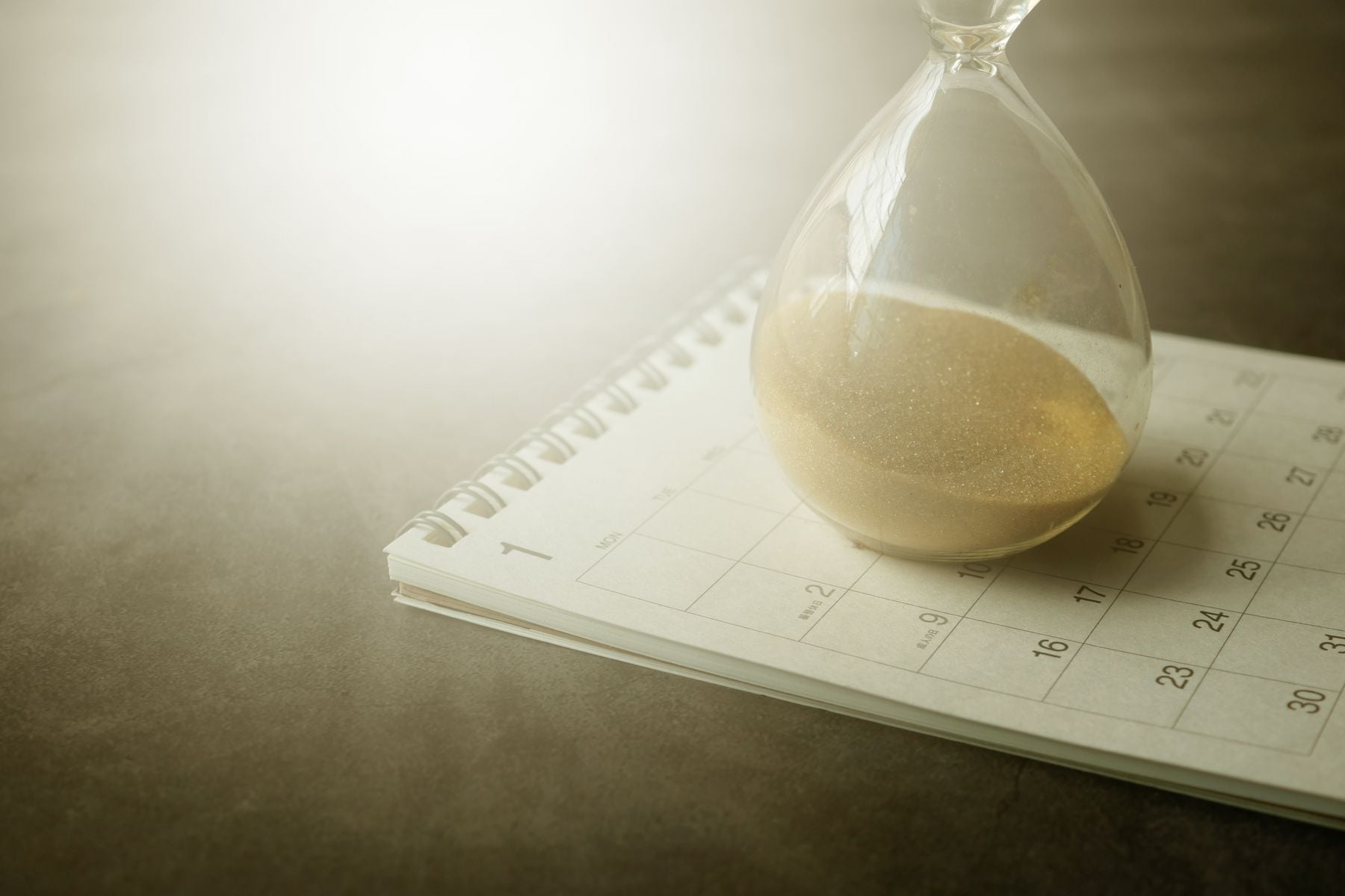 How Long Does It Take to Get an SBA Loan? 2 Hourglass resting on a calendar, showing the weeks an SBA loan takes to fund
