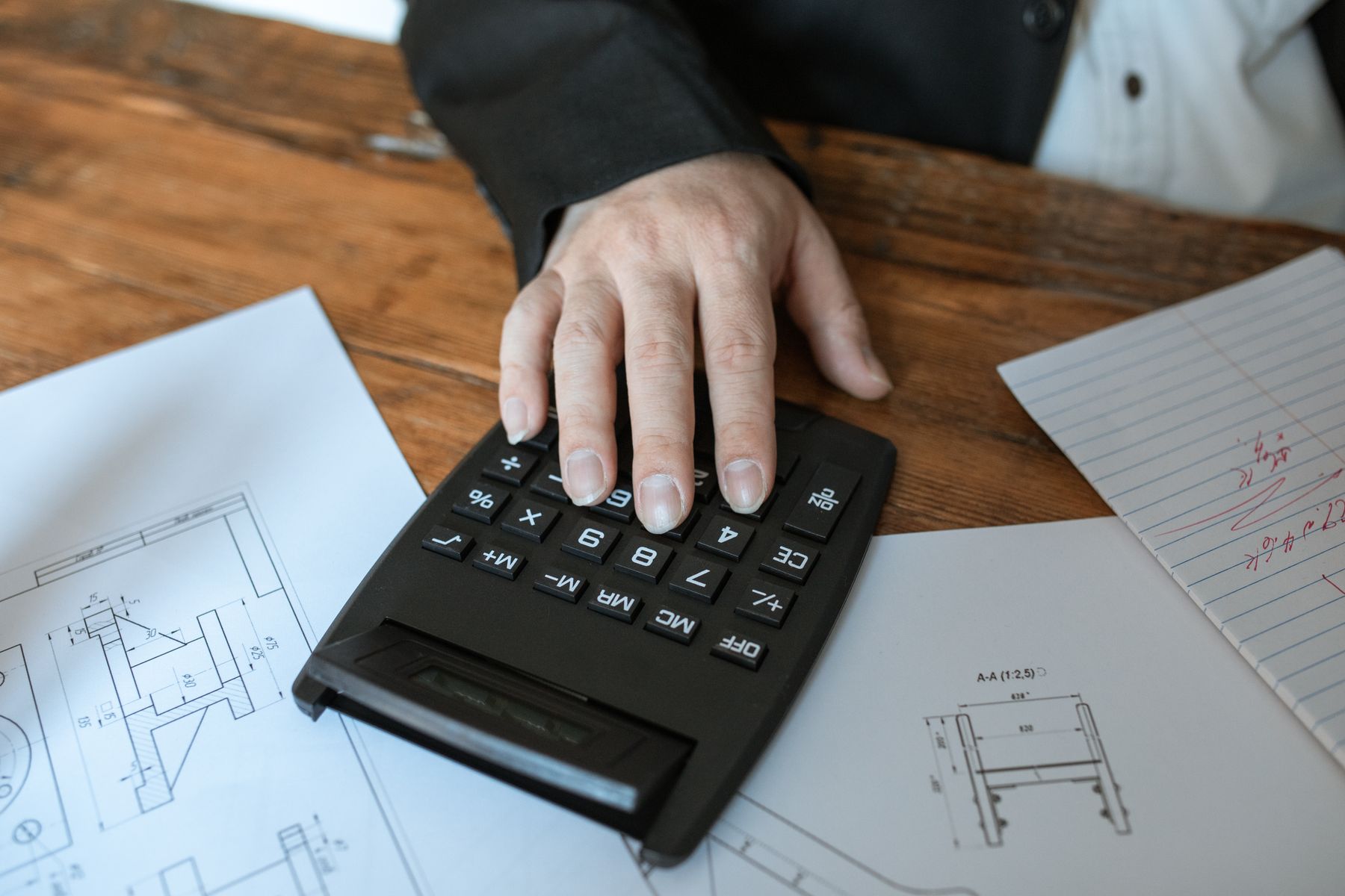 How Much Working Capital Does Your Small Business Actually Need? 2 Business owner working through figures on a calculator