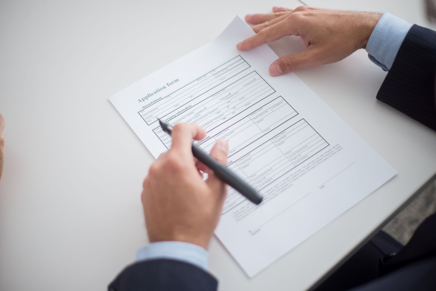 How to Apply for an SBA Loan in 2026: A Step-by-Step Guide 2 Business owner reviewing an SBA loan application form at a desk
