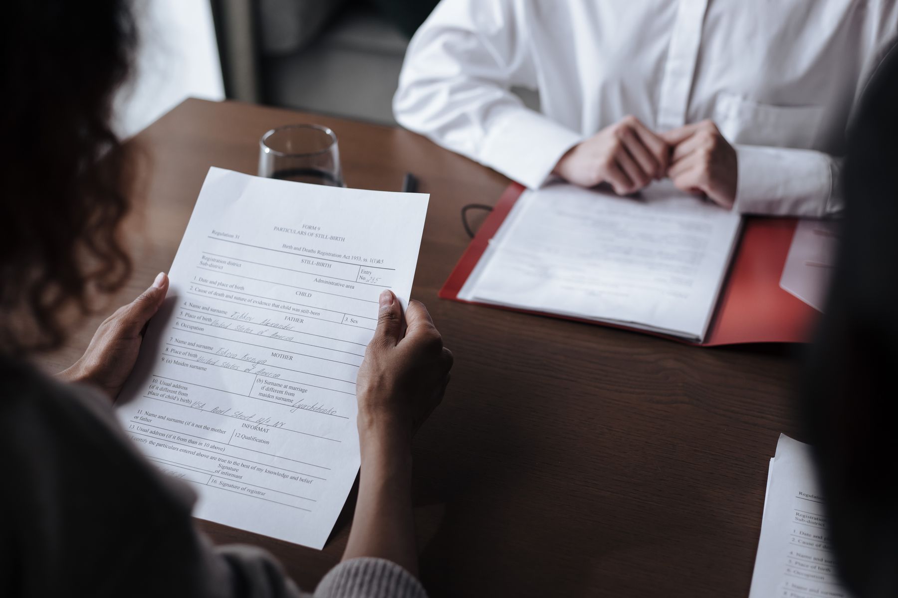 How to Compare Business Loan Offers From Multiple Lenders 2 Two people reviewing funding documents across a desk