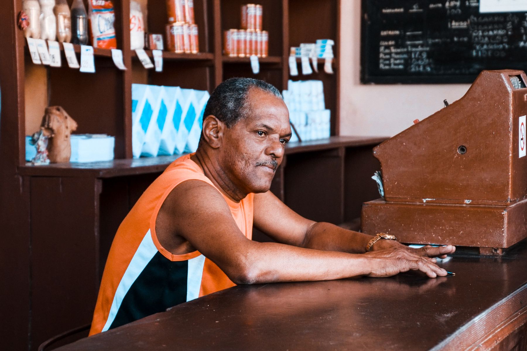 Stuck Without Cash Flow? Here's How to Get Working Capital Fast 2 Shop owner at his counter reviewing cash flow