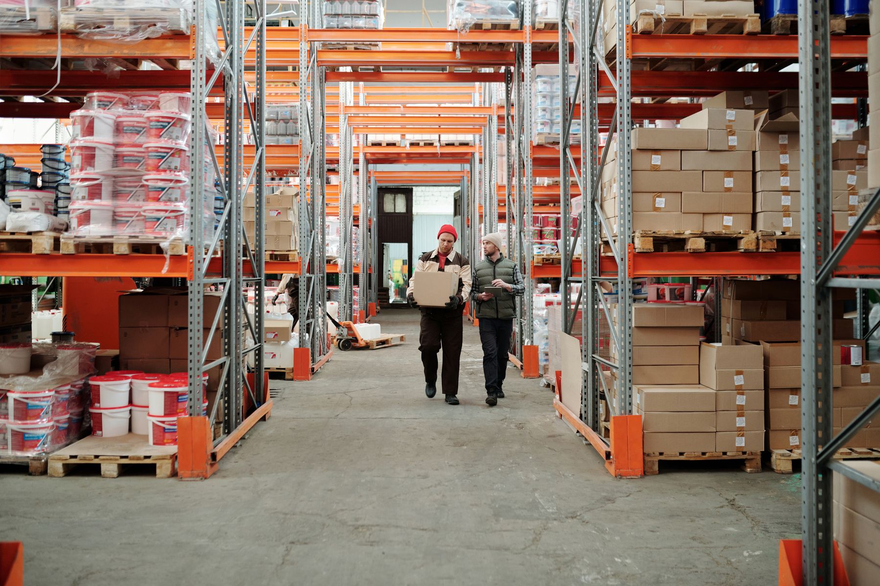 Invoice Factoring vs. Business Loans: Which Is Right for You? 2 Warehouse manager reviewing invoices beside pallets