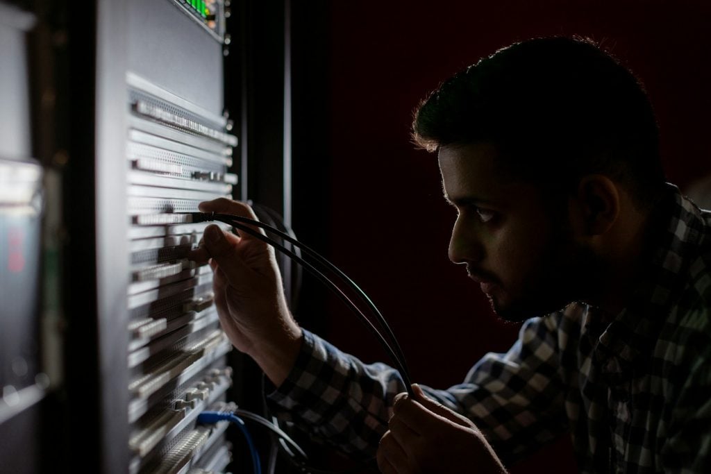 IT technician working on cabling at a server rack