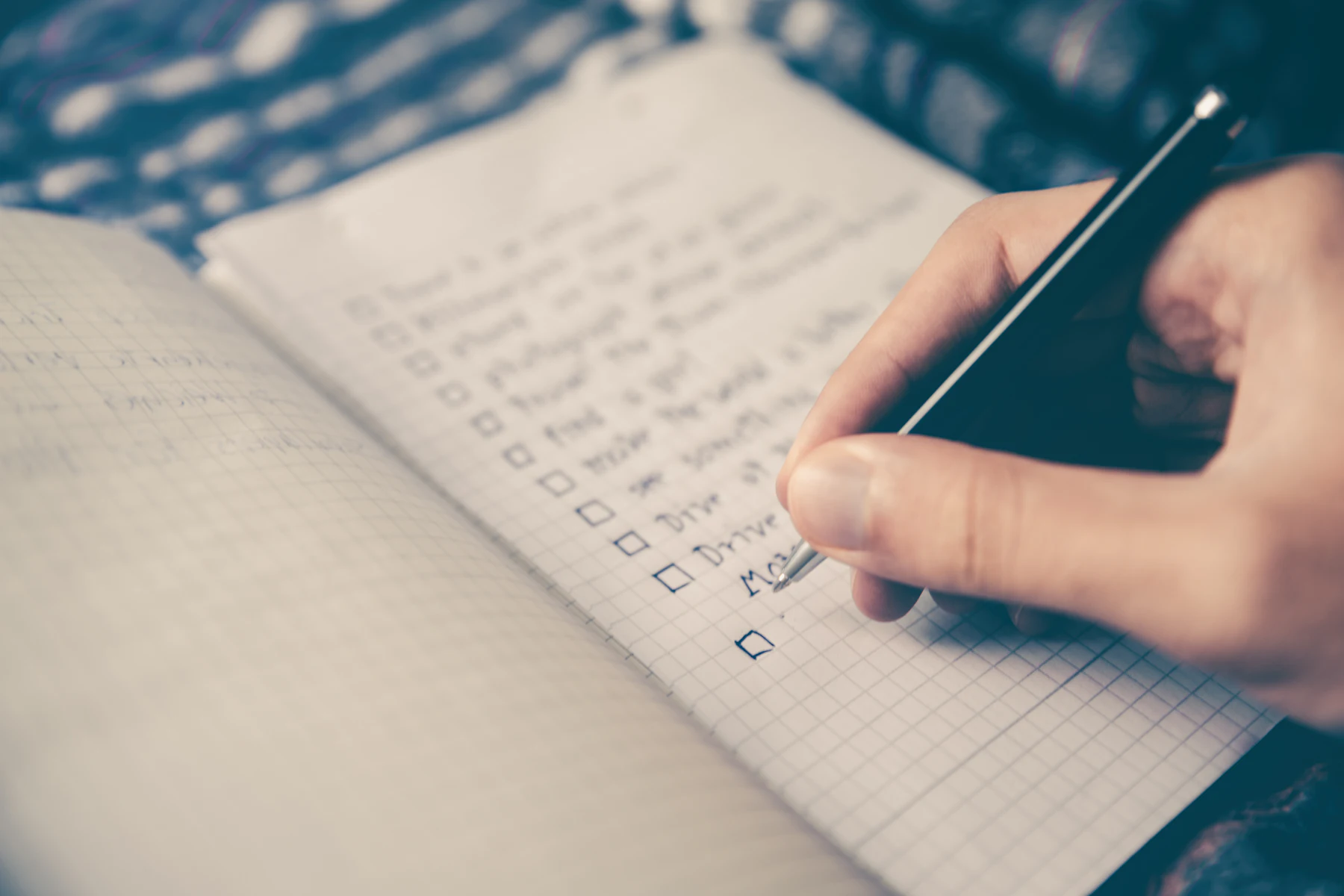Persona escribiendo a mano en un cuaderno