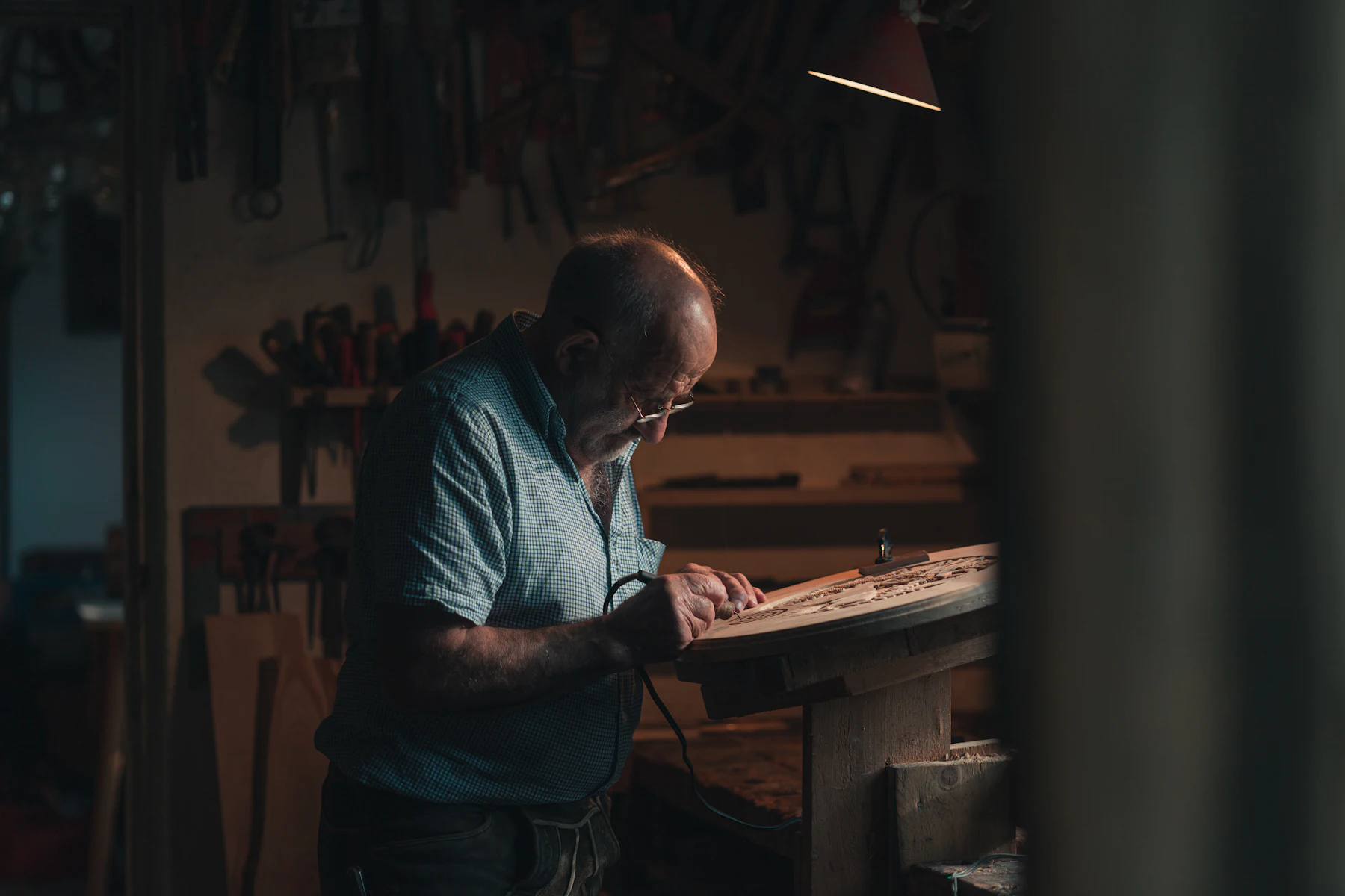Craftsman working at a bench in a dim workshop