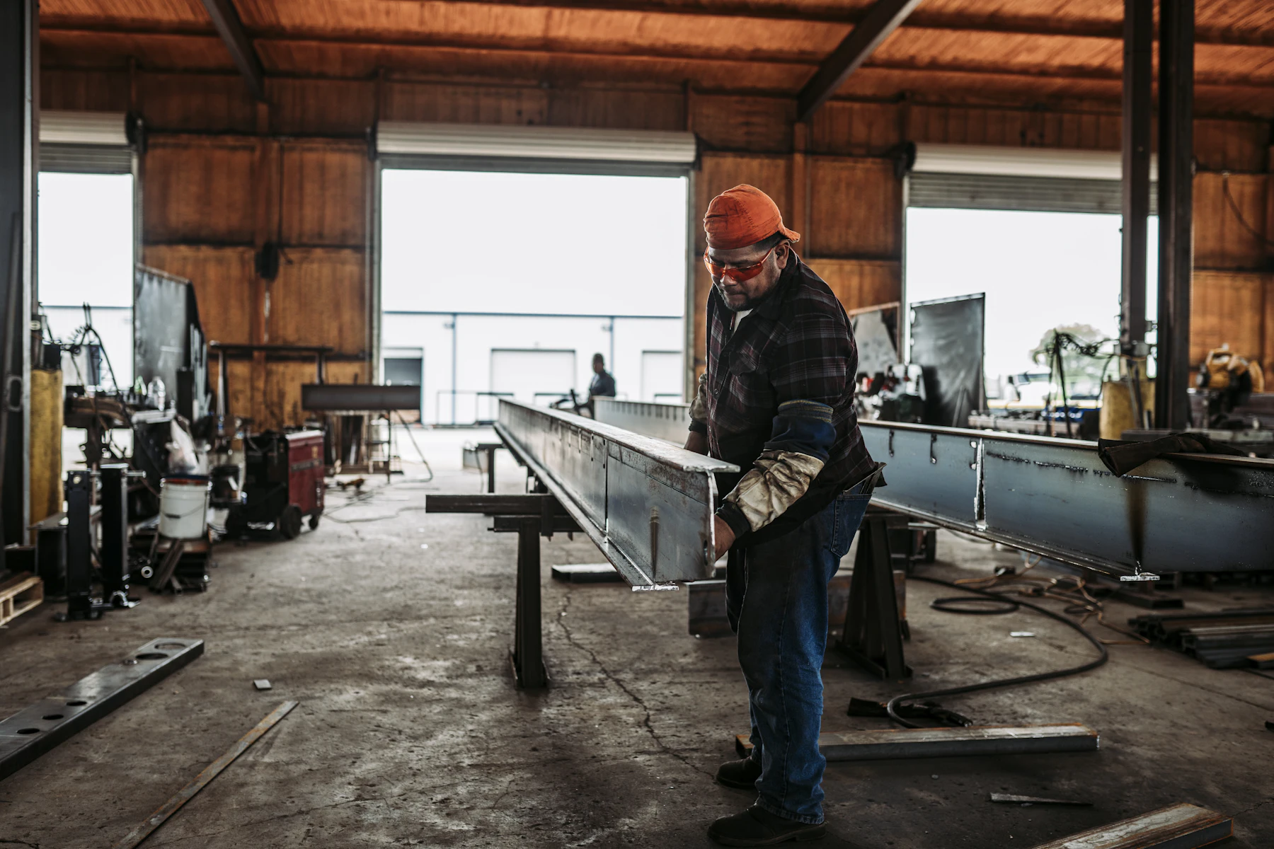 Same Purchase Order, Higher Costs: The Manufacturing Cash-Flow Squeeze 2 Worker standing beside equipment in a bright workshop