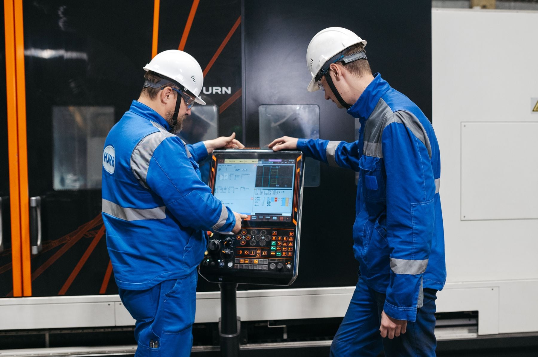 Manufacturing Equipment Financing: CNC, Presses, Automation and Production Lines (2026) 2 Engineers operating CNC machinery in a factory