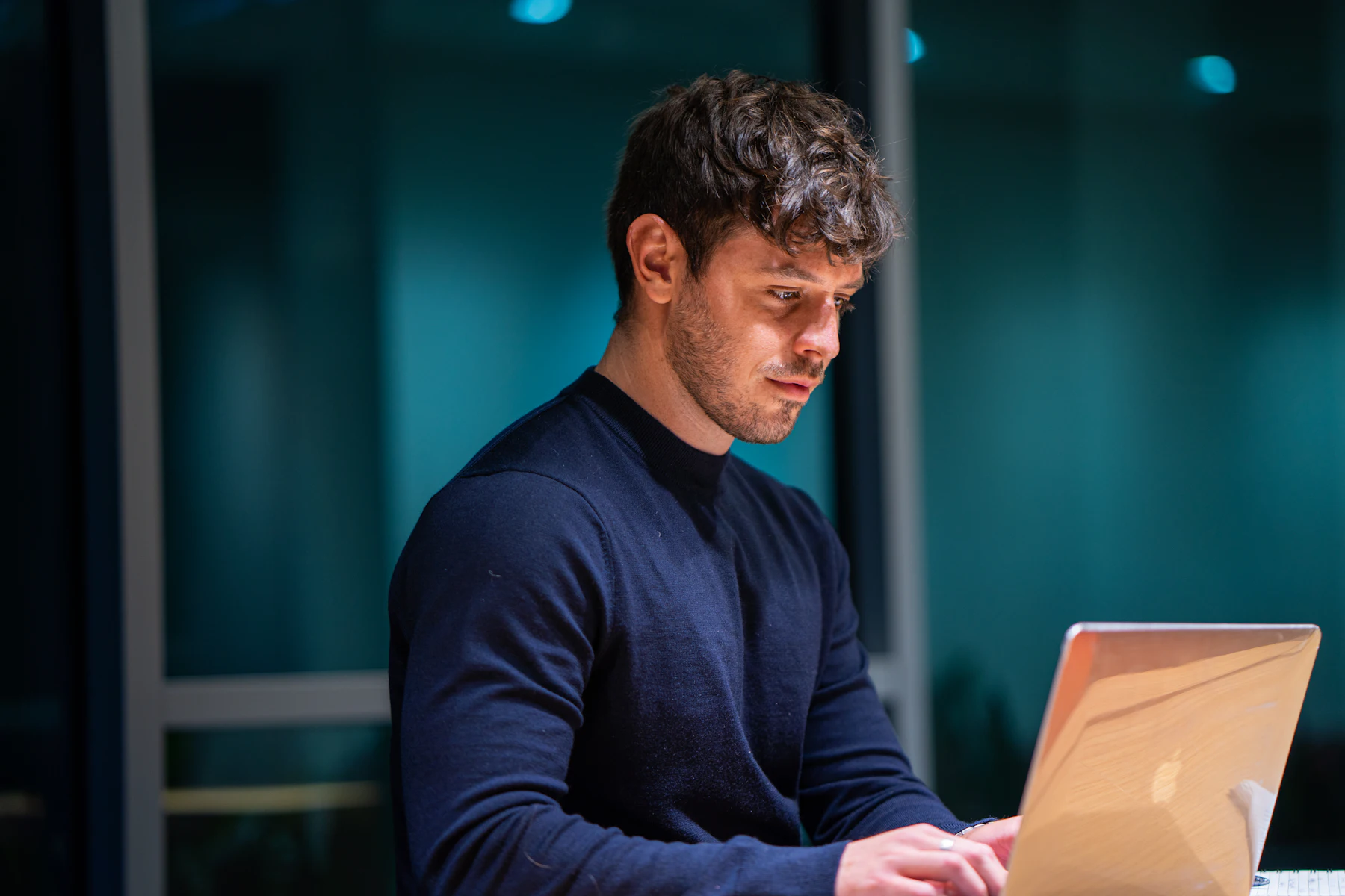 Online Business Loans: How They Work and How to Qualify 2 Man working on a laptop in a dimly lit office
