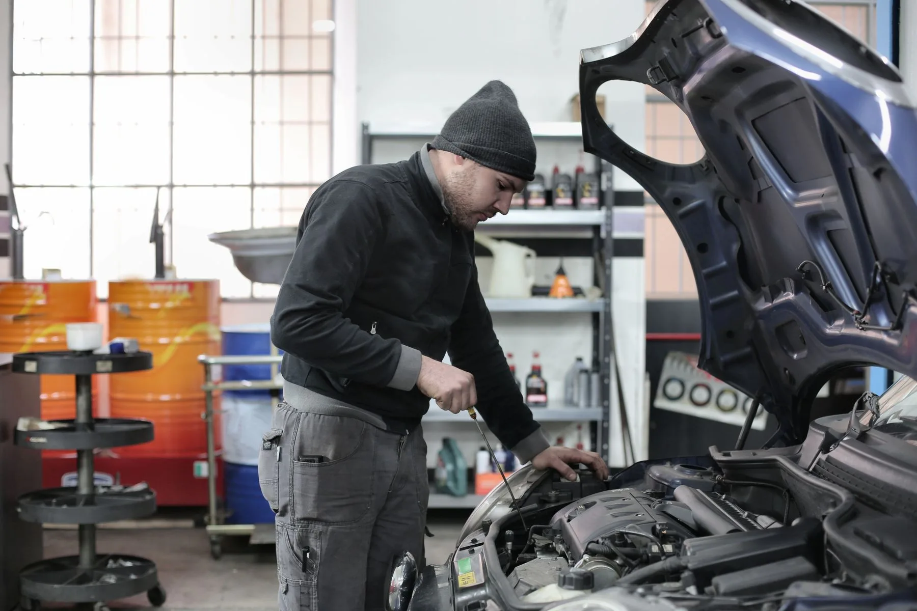 Opciones de préstamos para negocios si necesita dinero ya 2 Dueño de un taller revisando el motor de un auto