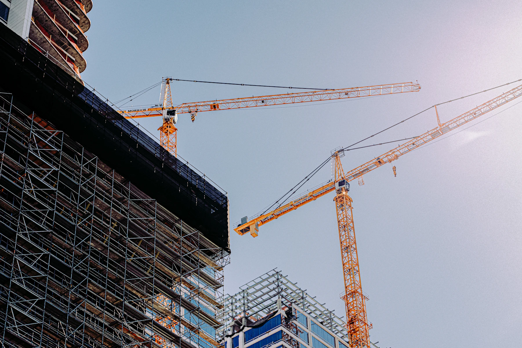 Préstamos Grandes para Negocios: Hasta $2 Millones en 72 Horas y Hasta $5 Millones con SBA 2 Grúas junto a un edificio en construcción
