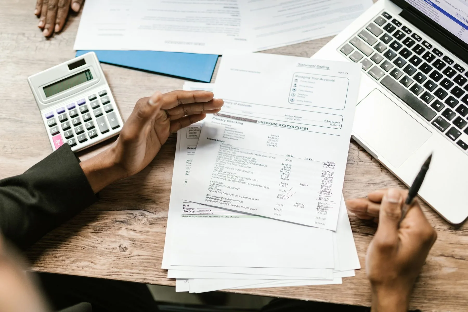 Préstamos para firmas de contabilidad: opciones y requisitos 2 Contador revisando documentos financieros con calculadora y laptop