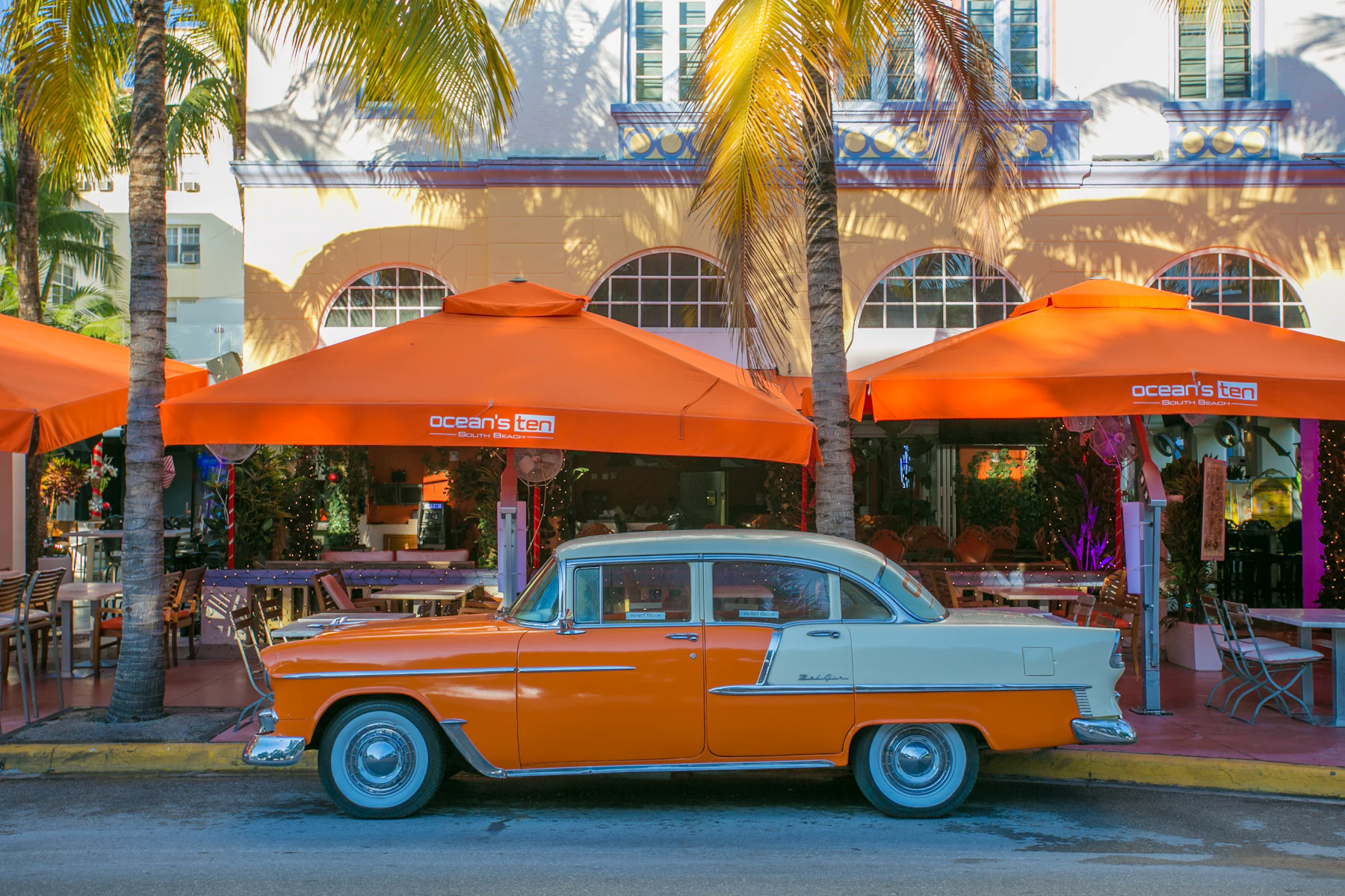 Préstamos para Negocios en Miami, FL: Financiamiento Rápido para Negocios Establecidos 2 Auto clásico naranja y blanco estacionado junto a una palmera
