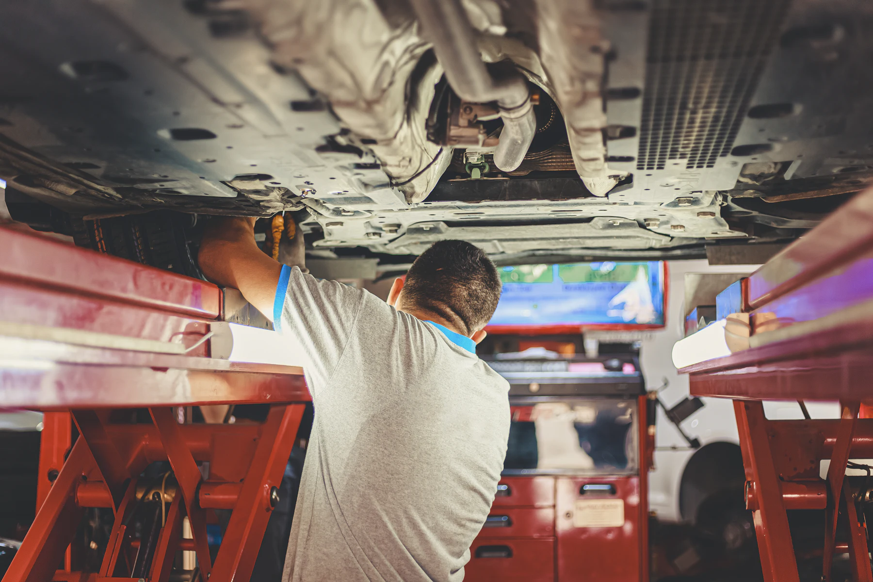 Mecánico trabajando debajo de un auto en un taller