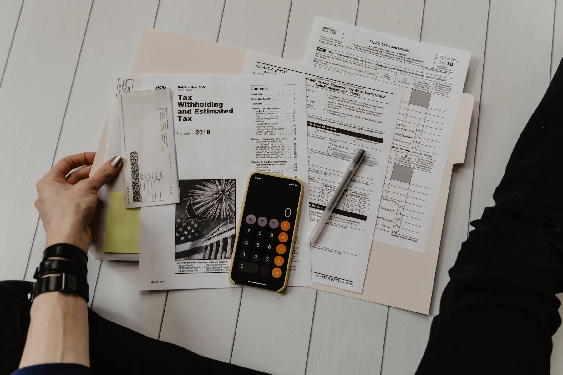 Préstamos Rápidos para Negocios: Ventajas, Desventajas y Costo 2 Mano con calculadora junto a formularios y documentos financieros
