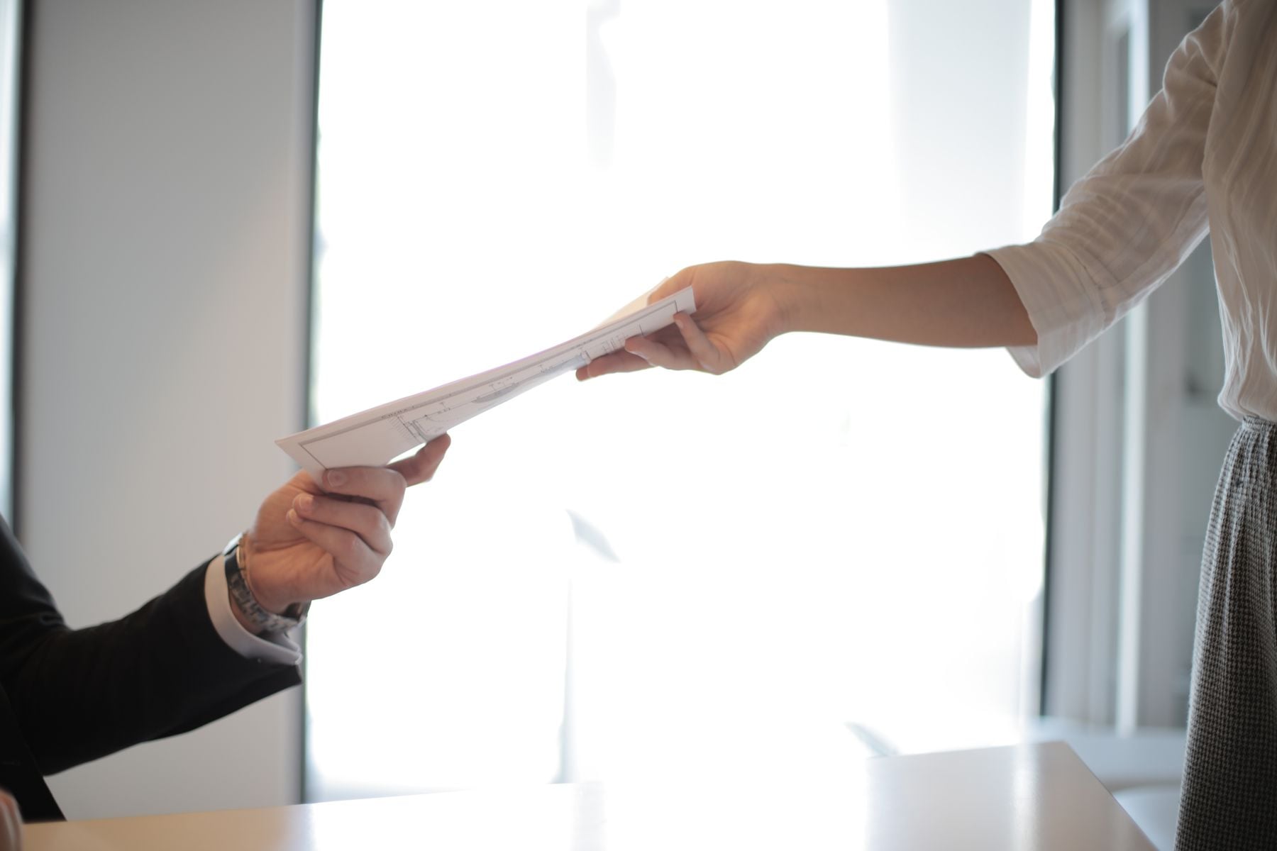 Purchase Order Financing: How PO Funding Works, What It Costs and Who Qualifies (2026) 2 Handing over a purchase order document across a desk