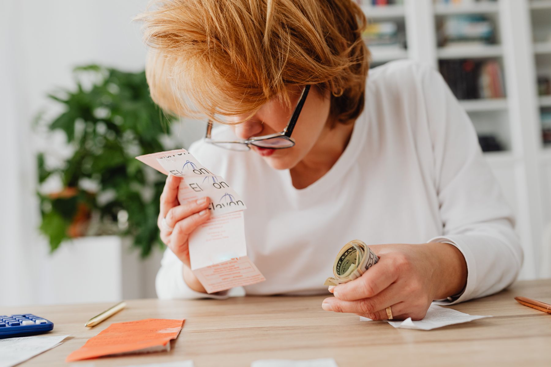 Reverse Consolidation for Merchant Cash Advances: How It Works and When to Use It 2 Business owner at a desk reviewing bills and cash flow before a reverse consolidation