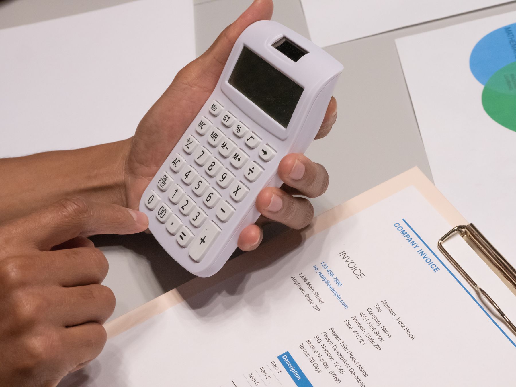 SBA Loan Fees Explained: Guaranty Fee, Packaging and Closing Costs (FY2027) 2 Hands using a calculator next to an invoice to work out SBA loan fees