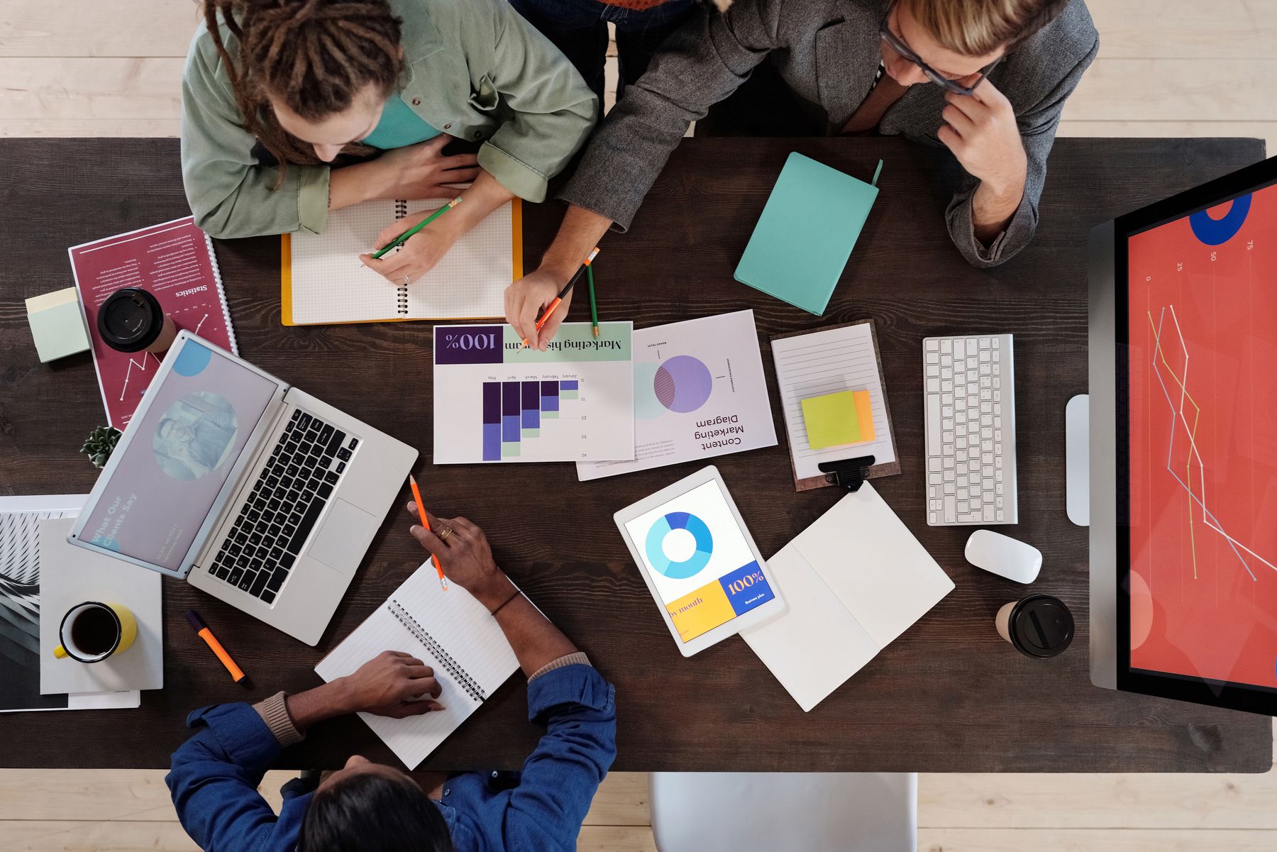 Tariffs and Small Business Working Capital in 2026: How Owners Are Funding Higher Inventory Costs 2 Business owners reviewing cost spreadsheets and charts at a work table