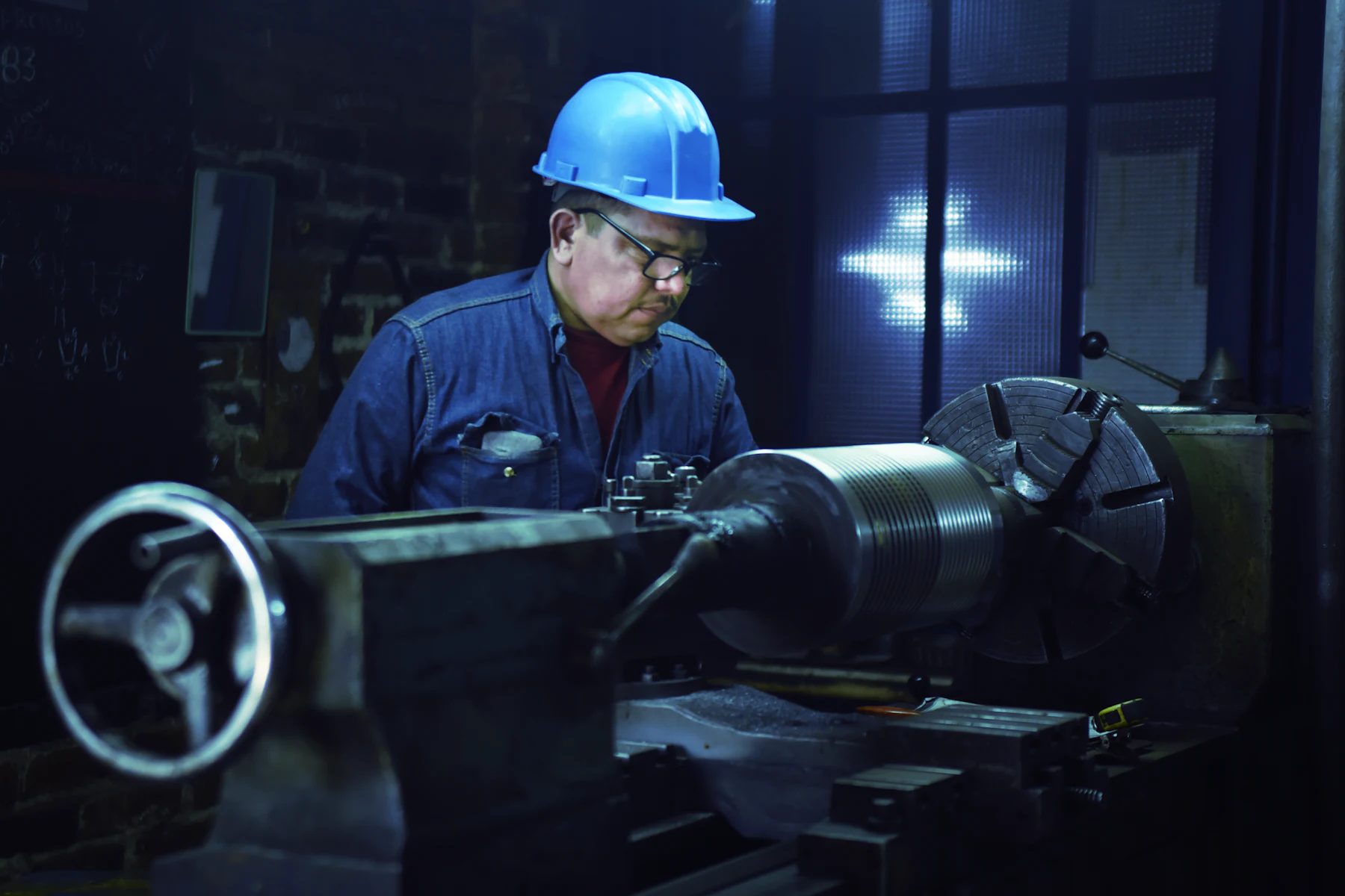 Tipos de Préstamos Rápidos para Negocios: 6 Opciones Comparadas 2 Operario con casco azul trabajando en un torno industrial