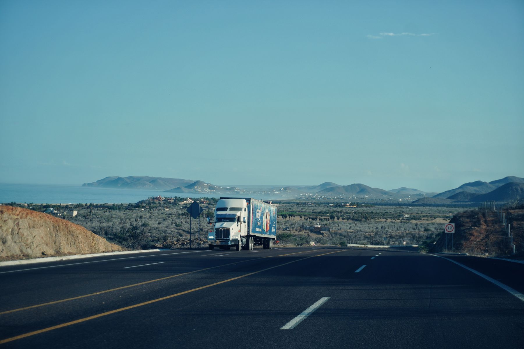 Semi-Truck and Trailer Financing: Rates, Requirements and Owner-Operator Programs (2026) 2 Semi-truck travelling on a scenic highway