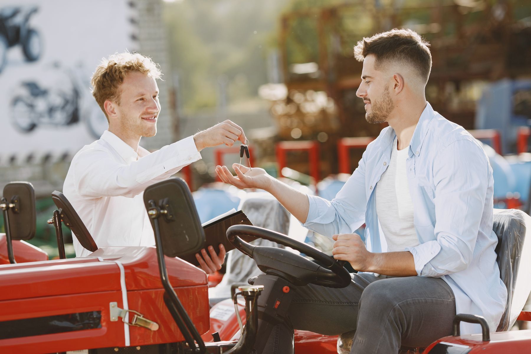 Used Equipment Financing: How to Finance Pre-Owned Trucks, Machinery and Tools 2 Buyer and seller shaking hands beside a red tractor